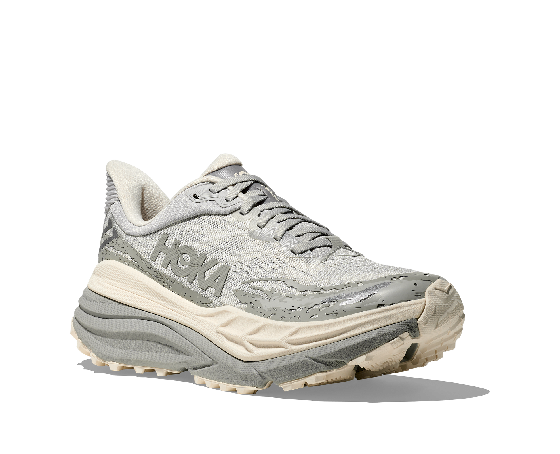 herrmodell. Hybridsko för alla underlag. En av Hokas stabilaste skor med pronationsstöd. En väldämpad sko som avlastar rygg och knä.  Gråa och vita nyanser på denna sko.