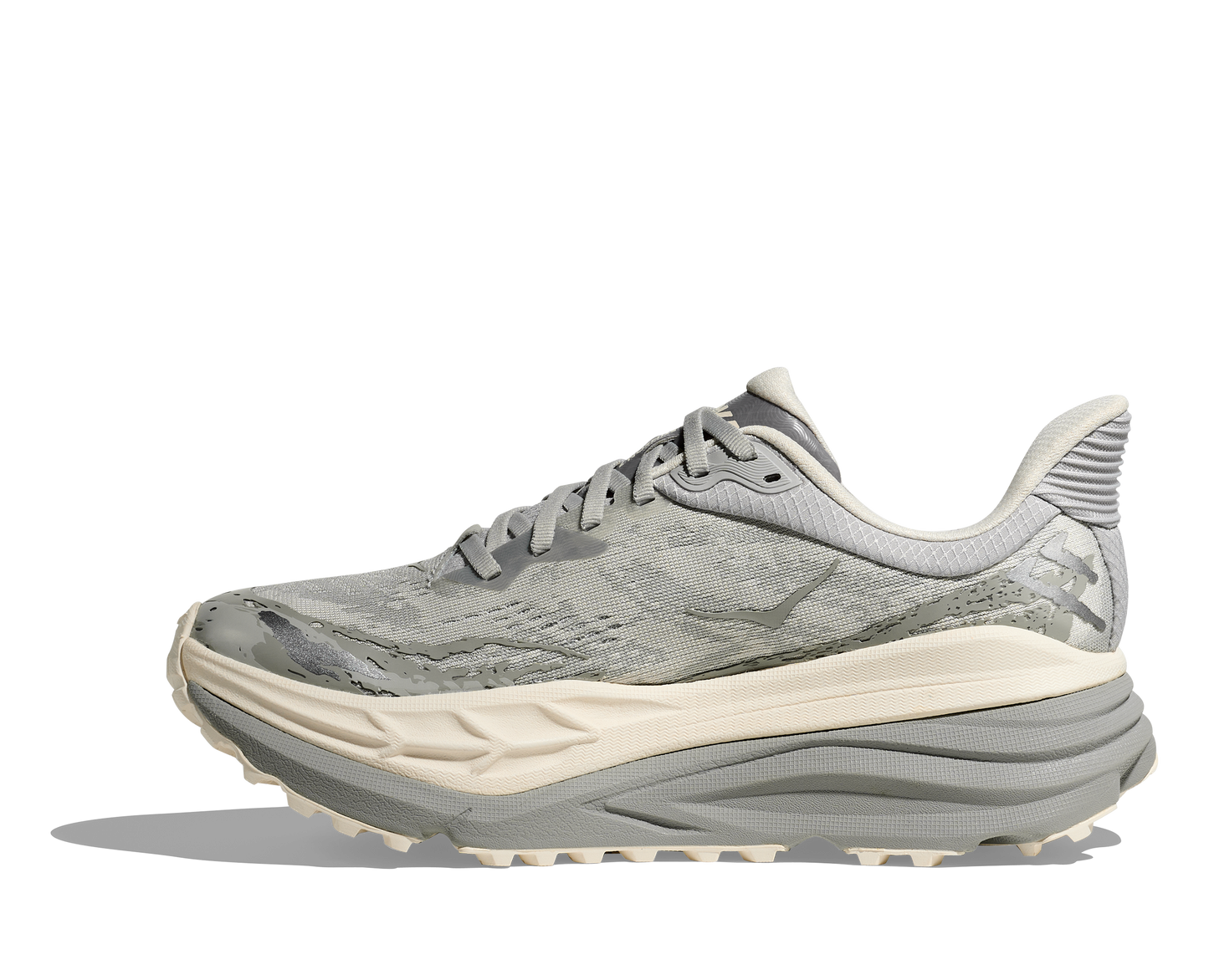 herrmodell. Hybridsko för alla underlag. En av Hokas stabilaste skor med pronationsstöd. En väldämpad sko som avlastar rygg och knä.  Gråa och vita nyanser på denna sko.