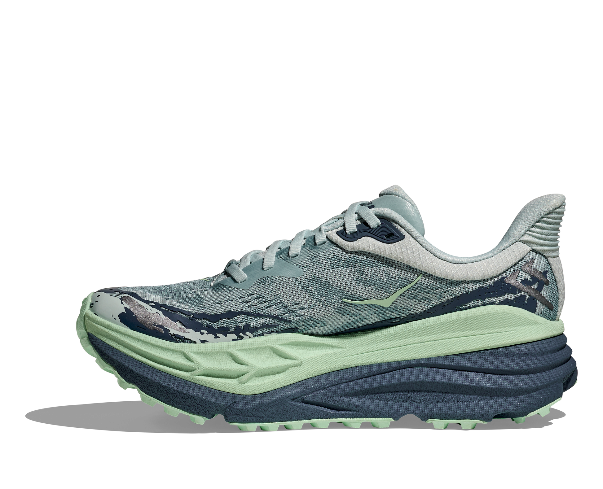 dammodell hybridsko för alla underlag. En av Hokas stabilaste skor med pronationsstöd. En väldämpad sko som avlastar rygg och knä. Färg i nyanser av grönt och blått.