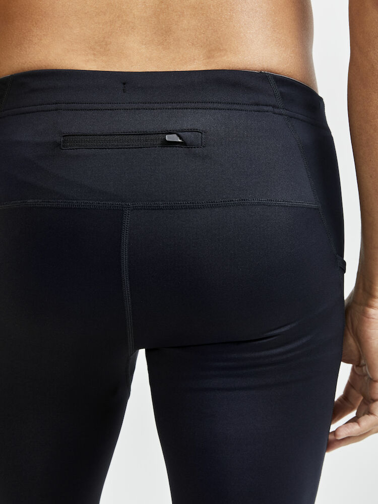 Craft ADV Essence Zip Tights. Svarta tights med elastiskt resår samt dragsko i midjan. Stor mobilficka höger ben. Ficka med dragkedja baktill. Dragkedja vid benslut. Reflekterande print baktill.