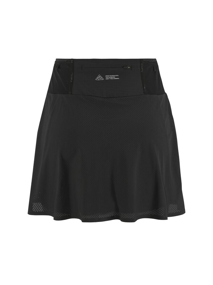 Craft PRO Trail Skirt W. Funktionell trailkjol för dam. Slitstarkt yttermaterial i 4-vägsstretch och elastiska innertights med effektiv pullback. Meshfickor runt midjan för snabb åtkomst och dragkedjeficka baktill. Mobilficka på höger ben. Regular fit - figurnära med rörelsefrihet. Här i svart.