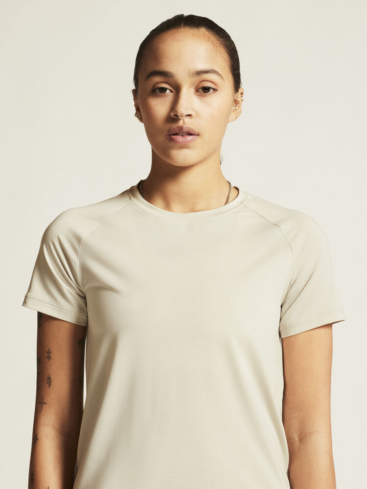 Craft Collective SS Tee W. Tränings-t-shirt med stilren design för dam. Raglanärmar och rundad nederkant för en feminin siluett. Här i beige.