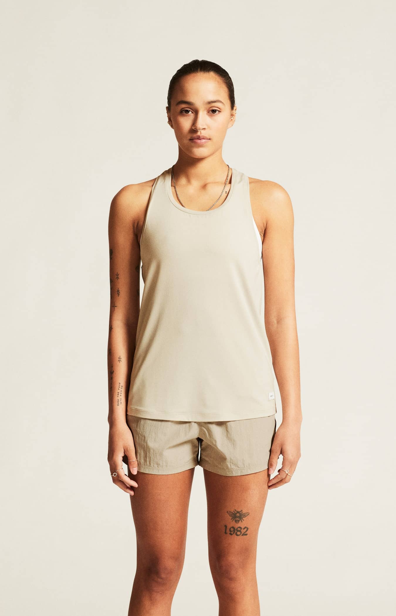 Craft Collective Singlet W. Träningslinne med stilren design till dam. Racerback-konstruktion och rundad nederkant för en feminin siluett. Här i beige med vit craft etikett nedtill fram.