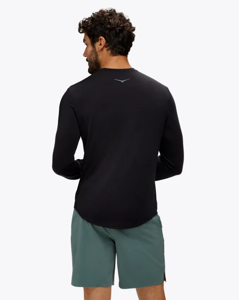 Extremt mjuk och bekväm långärmad svart tröja. Liten Hoka logo i mitten av skulderbladen i en grå färg. Denna tröja har en smal passform men den är inte tight.