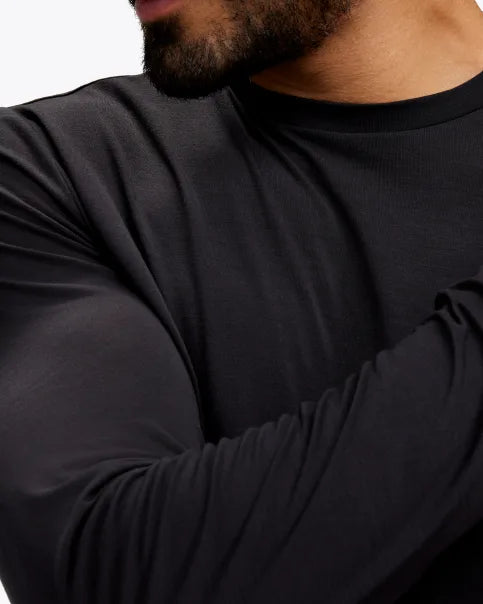 Extremt mjuk och bekväm långärmad svart tröja. Liten Hoka logo i mitten av skulderbladen i en grå färg. Denna tröja har en smal passform men den är inte tight.